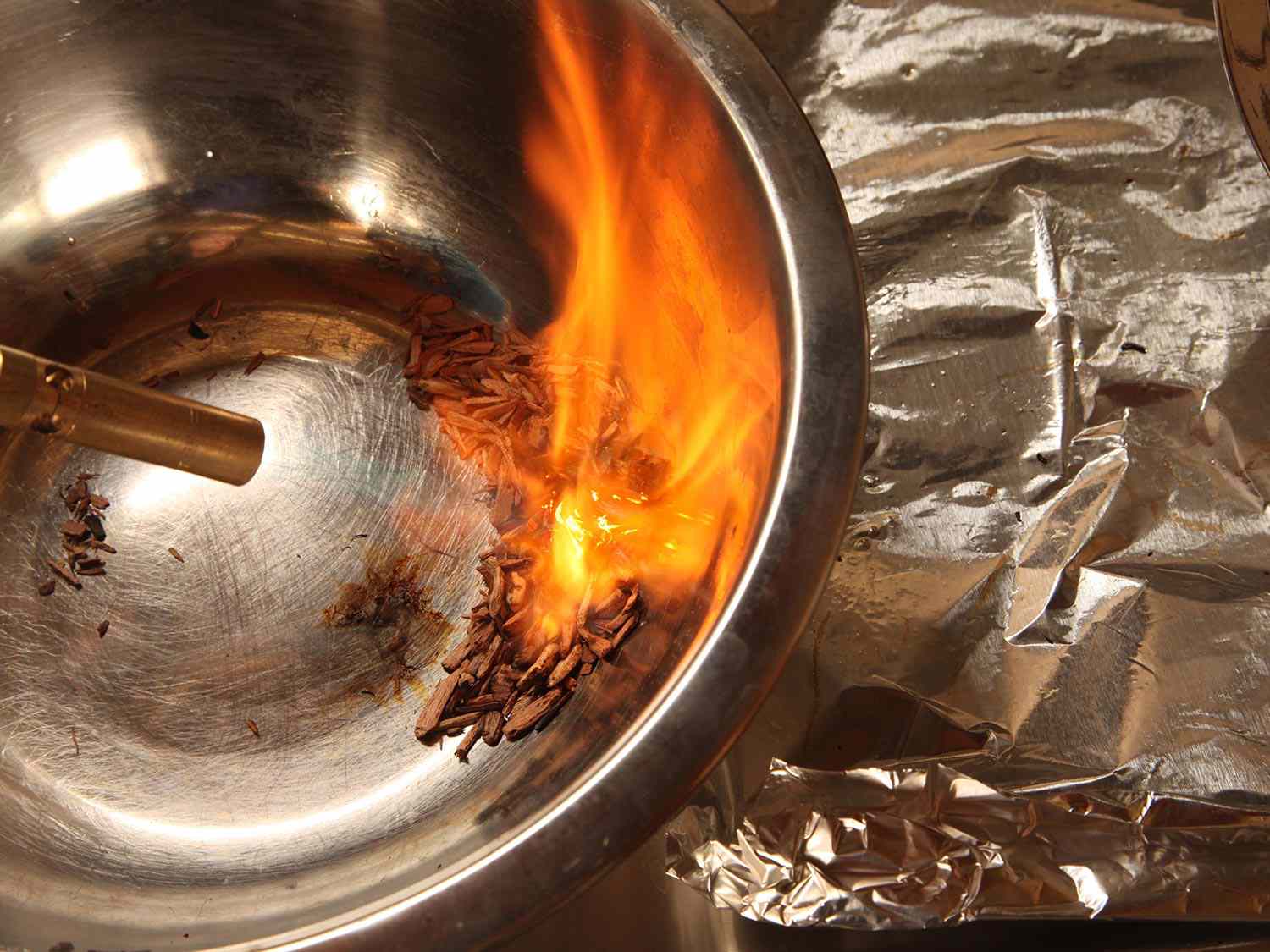 用喷灯点燃金属搅拌碗里的木屑。