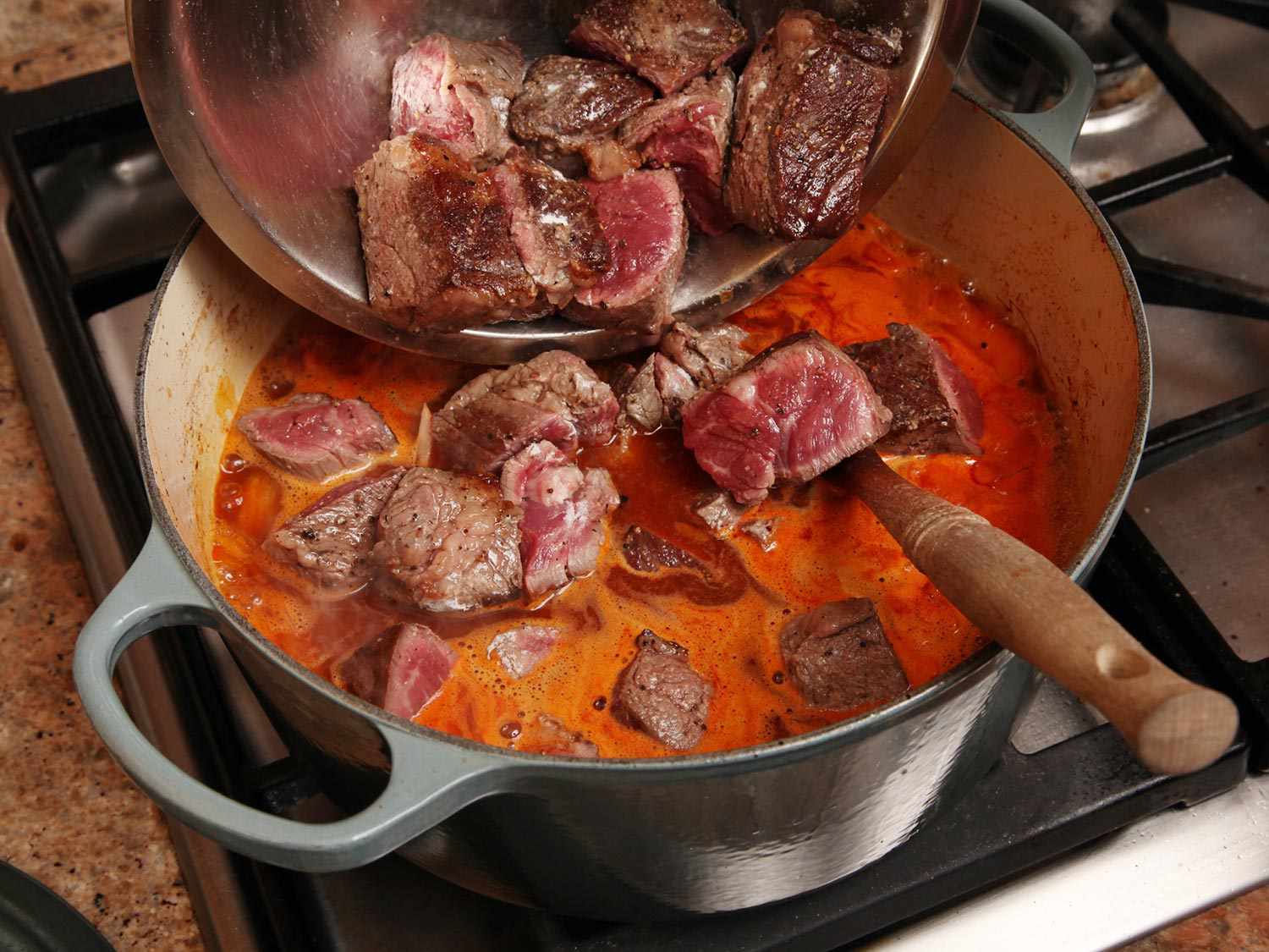 在炖牛肉锅中加入棕色的牛肉块。