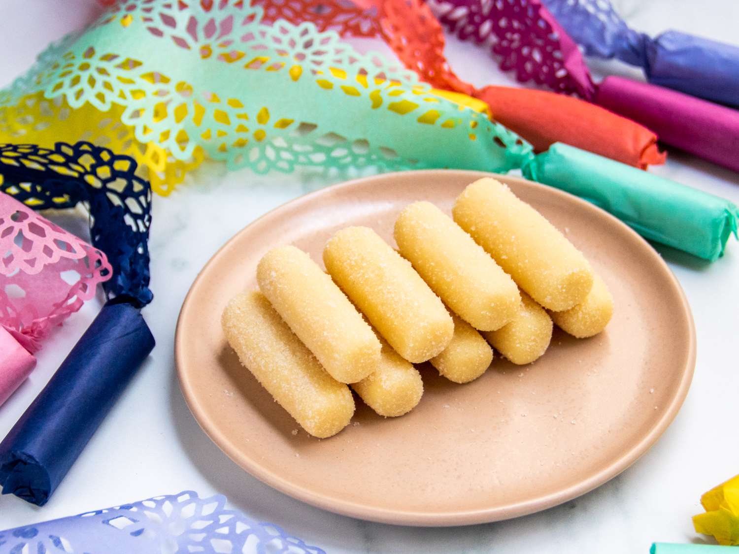 a plate of pastillas de leche with some in hand-cut wrappers in the background