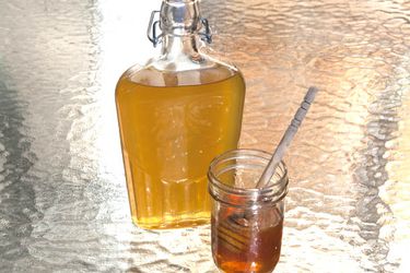 一瓶蜂蜜利口酒旁边是一罐蜂蜜