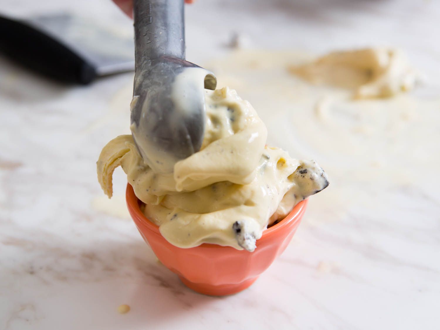 把有嚼劲的新英格兰式冰淇淋放在大理石表面上，舀到盛冰淇淋的碗里。