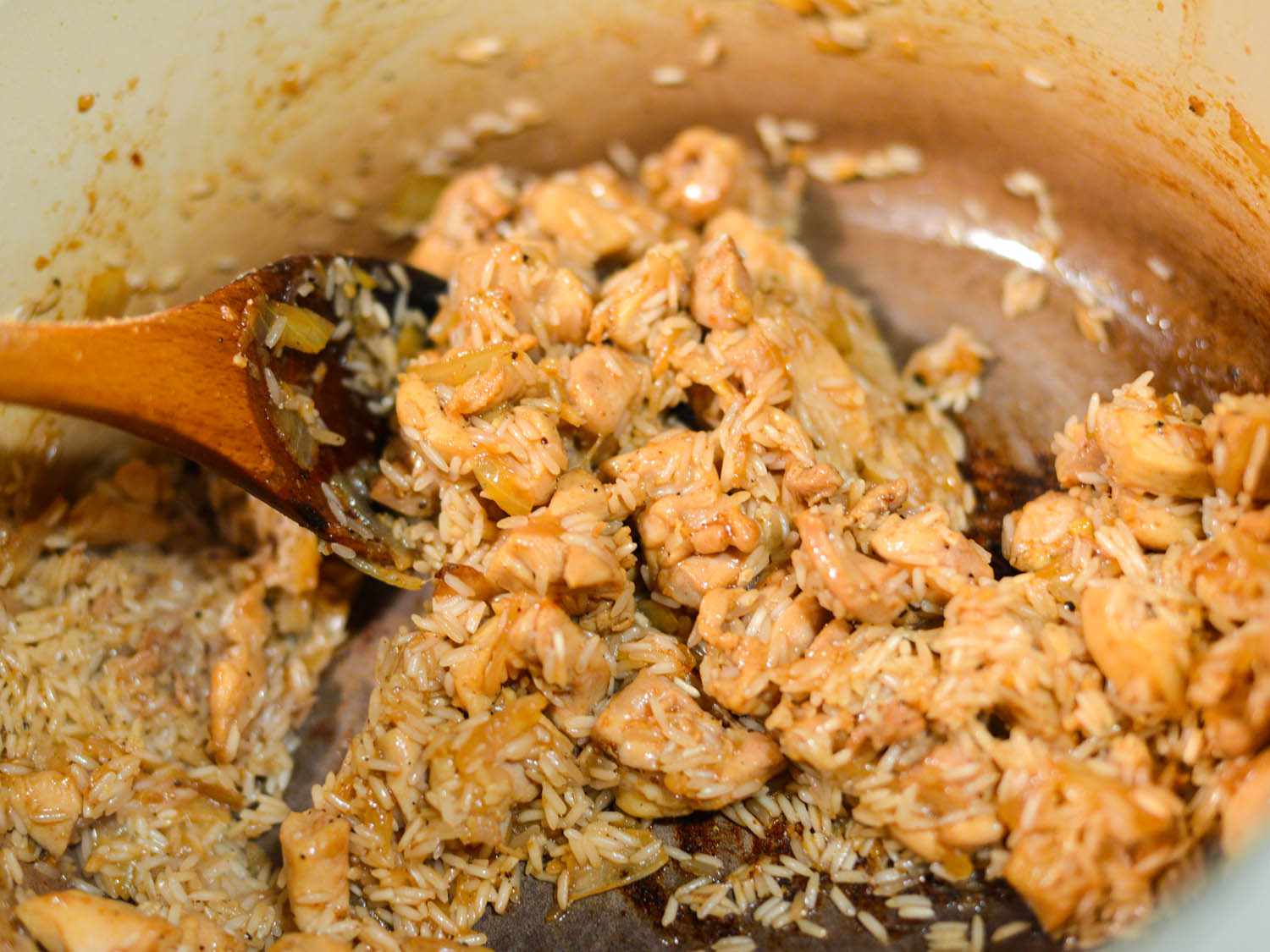 米饭被搅拌到鸡肉洋葱混合物中。