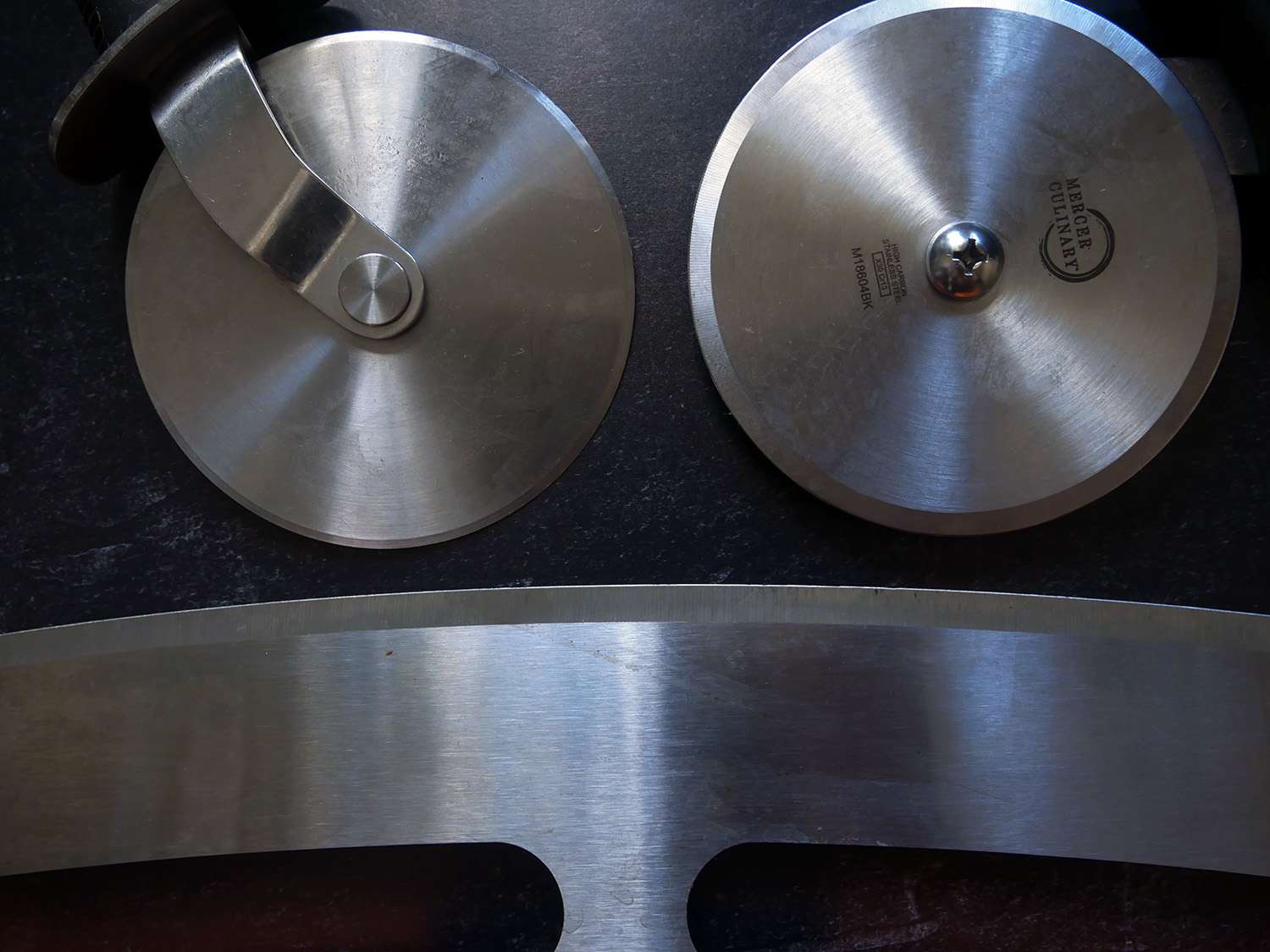 a closeup of the metal blades on our three winning pizza cutters