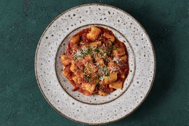 意大利乳清干酪汤圆加番茄酱放在陶瓷盘子里。