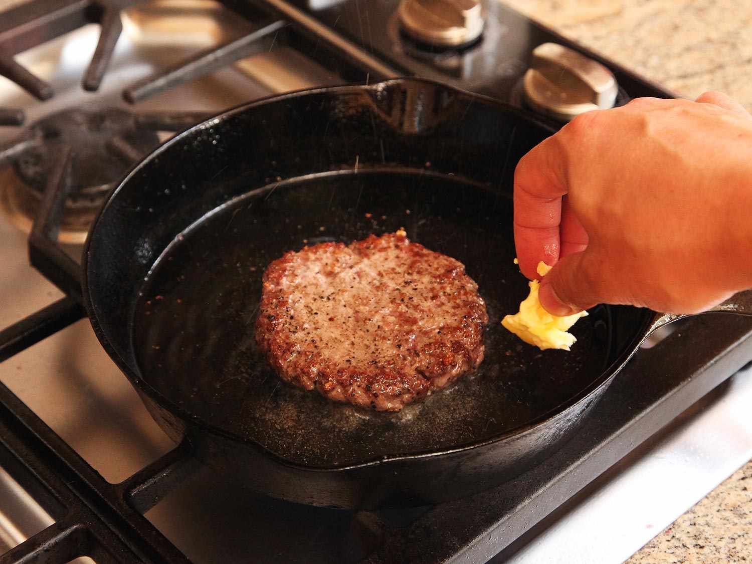 在一个铸铁煎锅中加入黄油，在煎的过程中放入一个真空烹饪汉堡。gydF4y2Ba