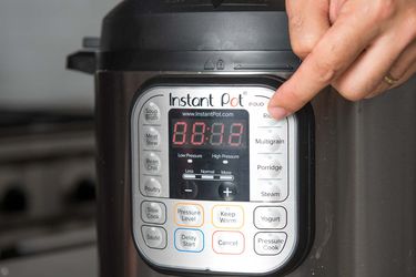 Person selecting rice function on Instant Pot multi-cooker.