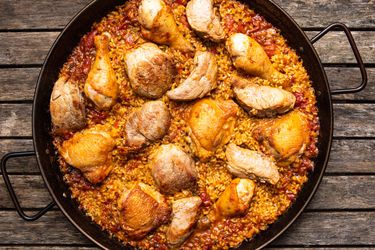 Grilled chicken and pork paella in a paella pan