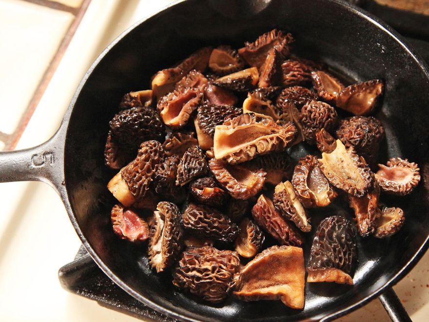羊肚菌菇放在炉子上的铸铁锅里