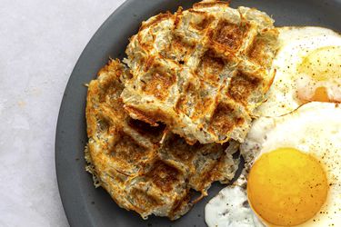 华夫饼煎饼放在盘子里，鸡蛋单面朝上。