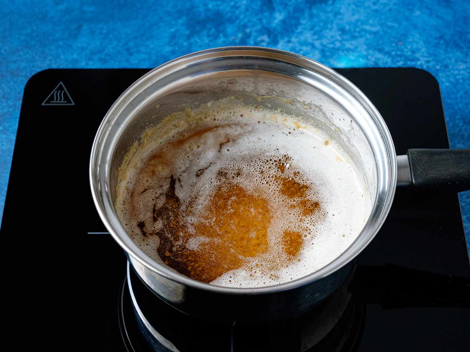一锅沸腾的黄油和牛奶蛋白沉入锅底
