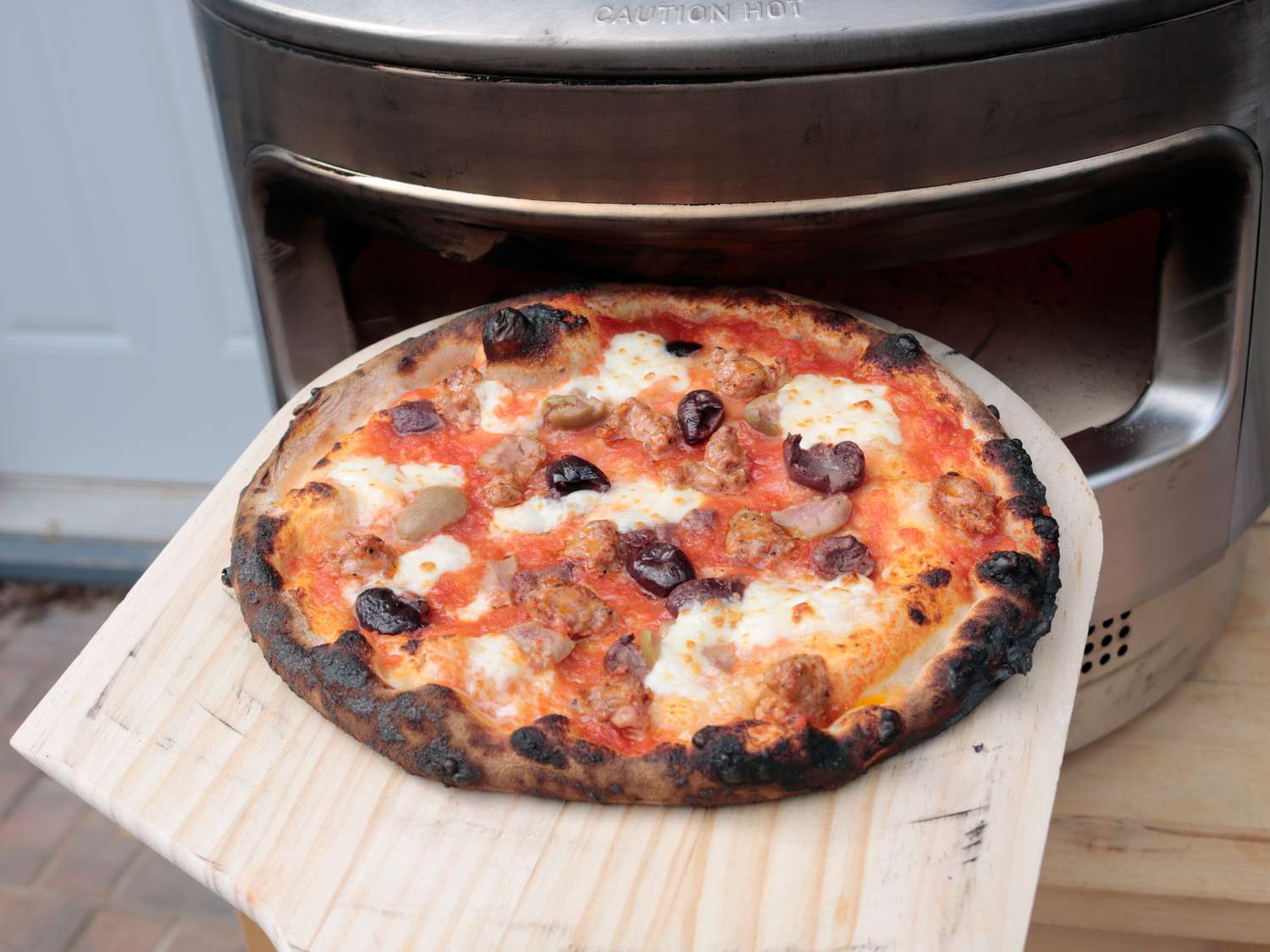 a cooked pizza with a charred outer crust