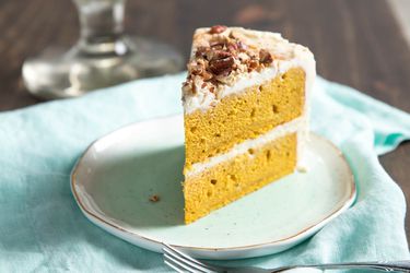 A slice of frosted pumpkin layer cake.