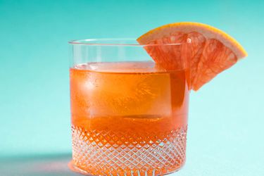 这是一款不寻常的尼格罗尼酒，用岩石酒杯盛，杯口有葡萄柚的楔子。