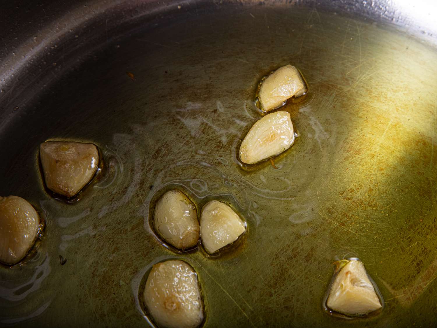 整瓣或几乎整瓣的大蒜在锅里用油慢慢煮