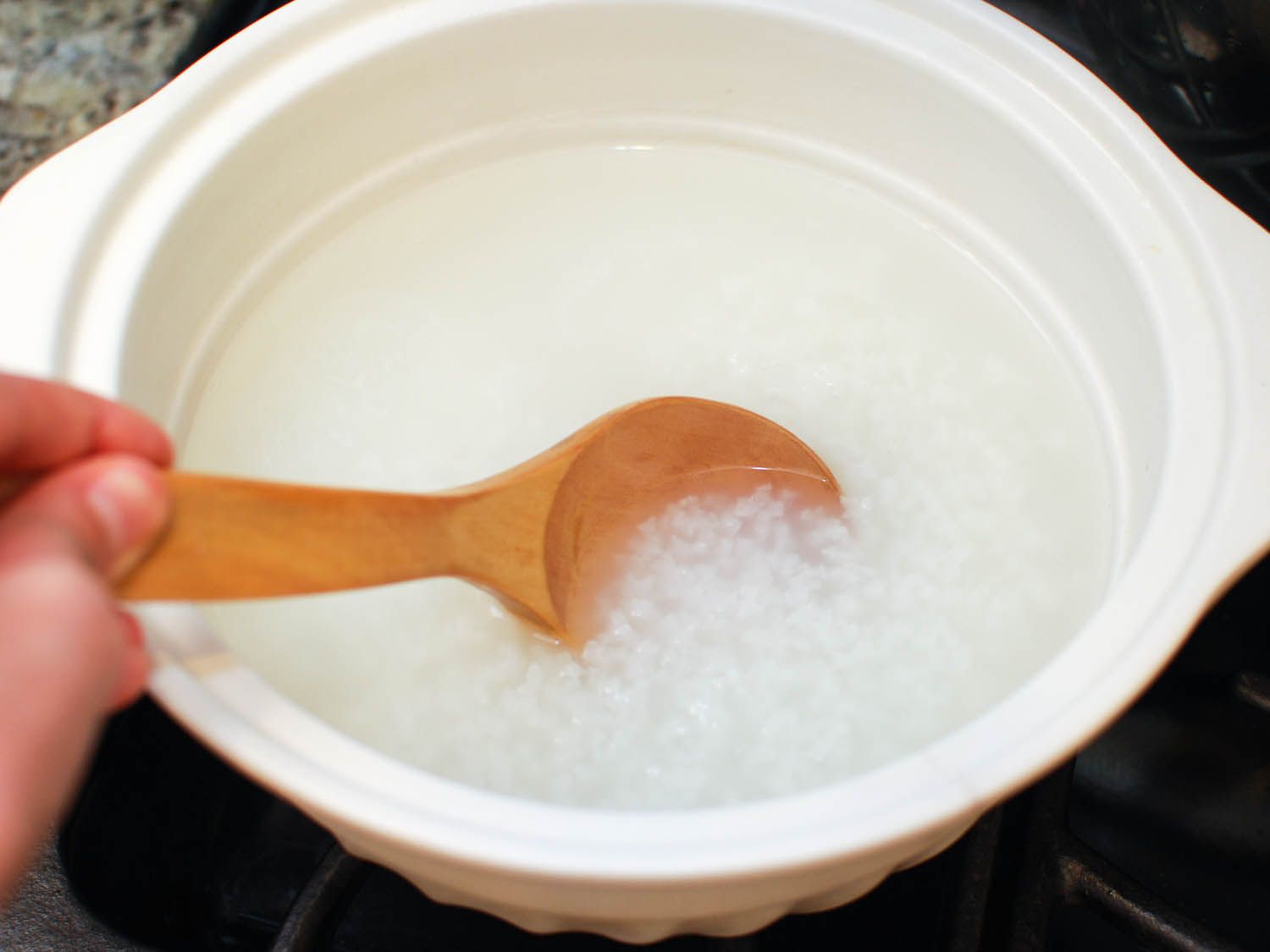在水里搅拌短粒米做粥。