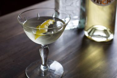 A white negroni cocktail served in a coupe glass.