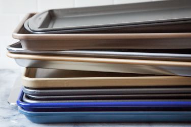 nonstick sheet pans stacked on each other on a marble countertop