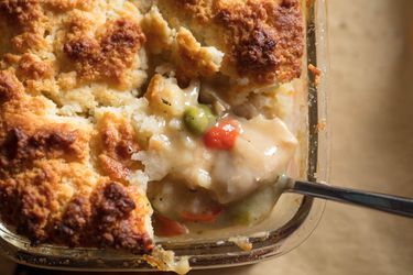 Close up of a corner of a chicken pot pie with biscuit topping.