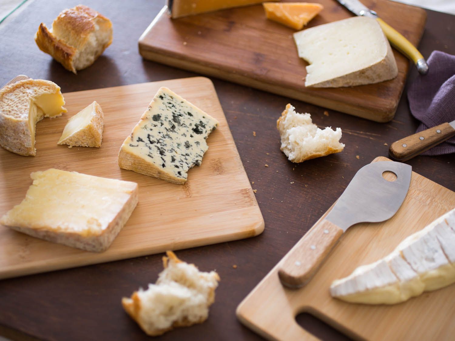 a variety of cheese on different wooden cheese boards