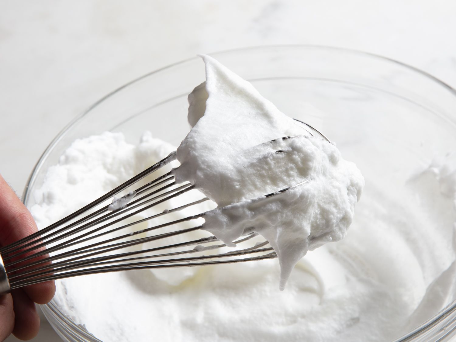 A whisk showing off stiff egg white peaks