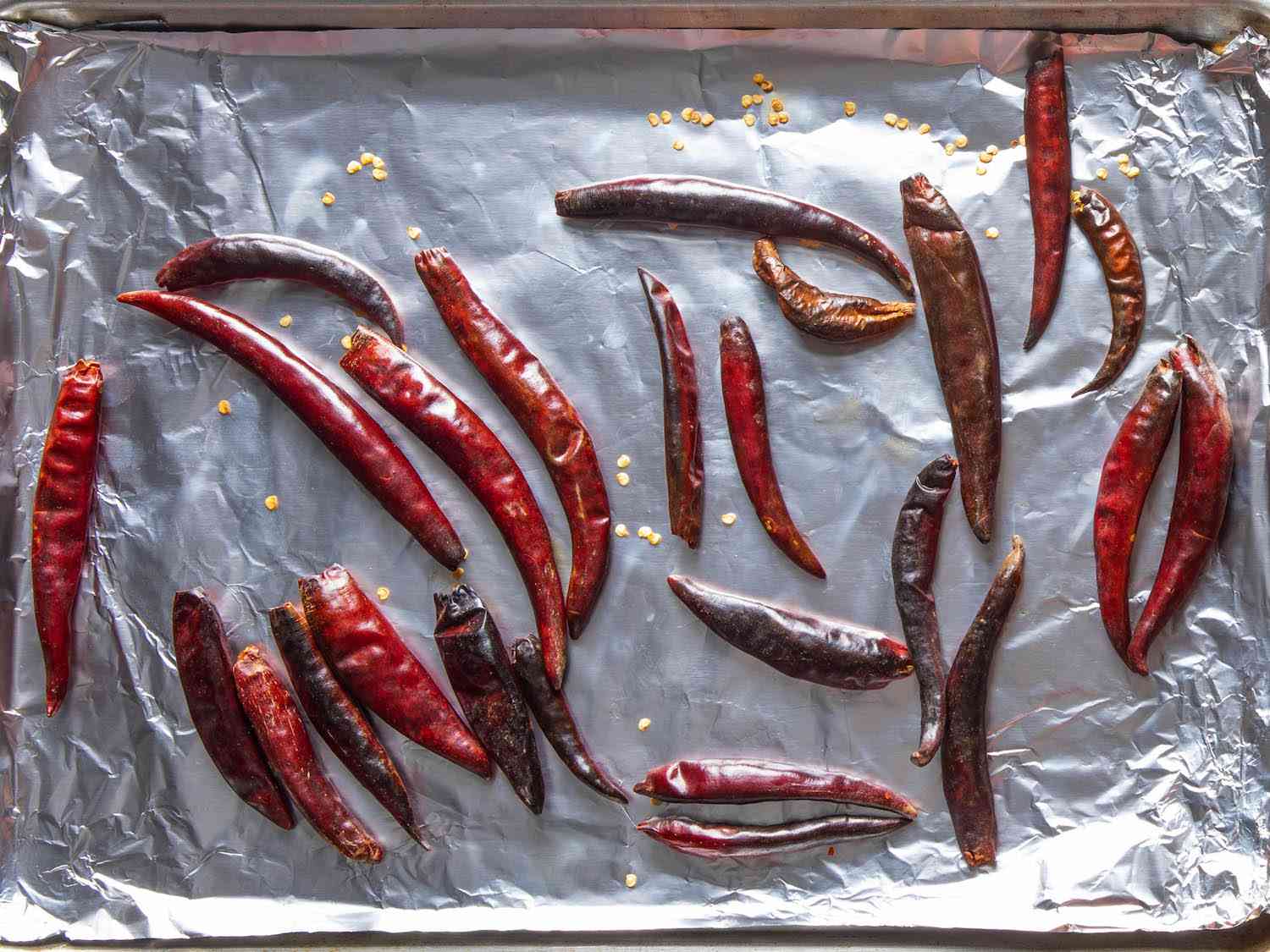 把干辣椒放在衬箔的烤盘上，烤至有斑点的地方略焦。