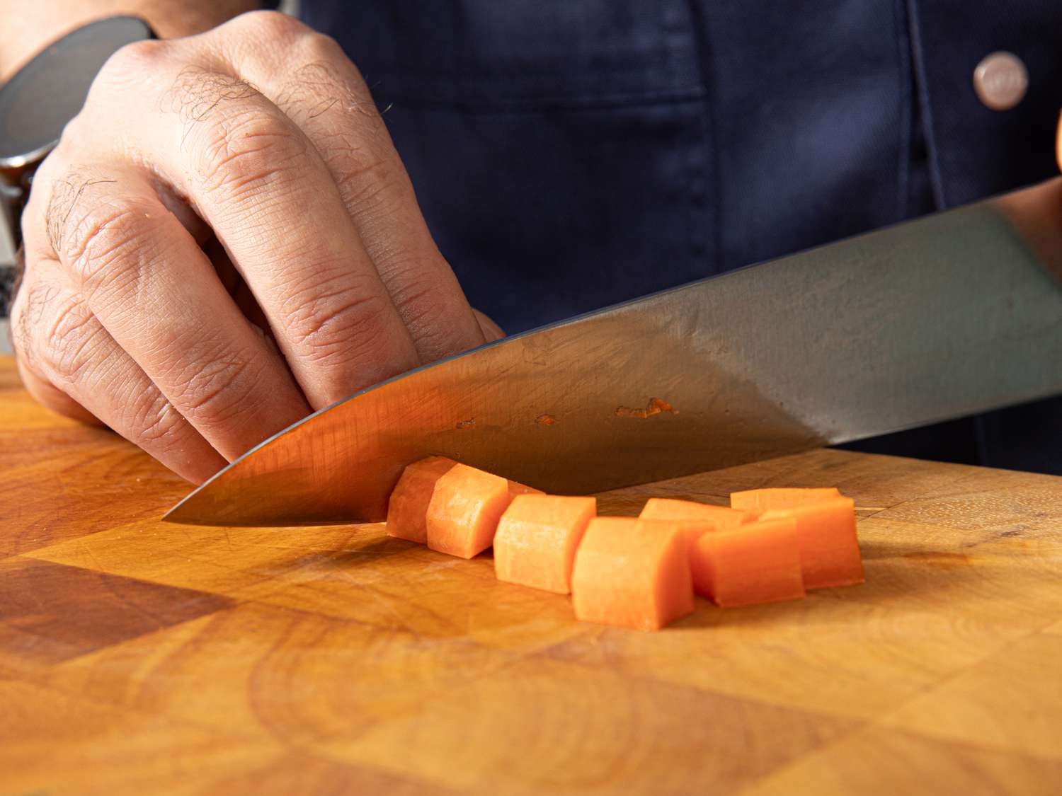 Side view of cutting carrots into small chunks