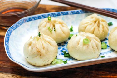 生煎包的小盘(煎猪肉soup dumplings), sprinkled with sliced scallions.