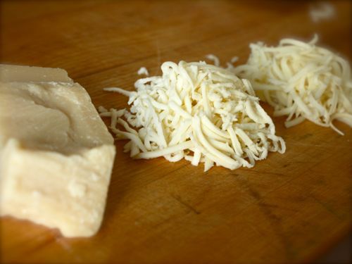 在一个奶酪里的一堆奶酪，把奶酪切成两半的奶酪。