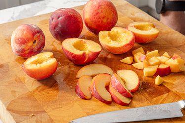 Side view of peaches on a cutting board