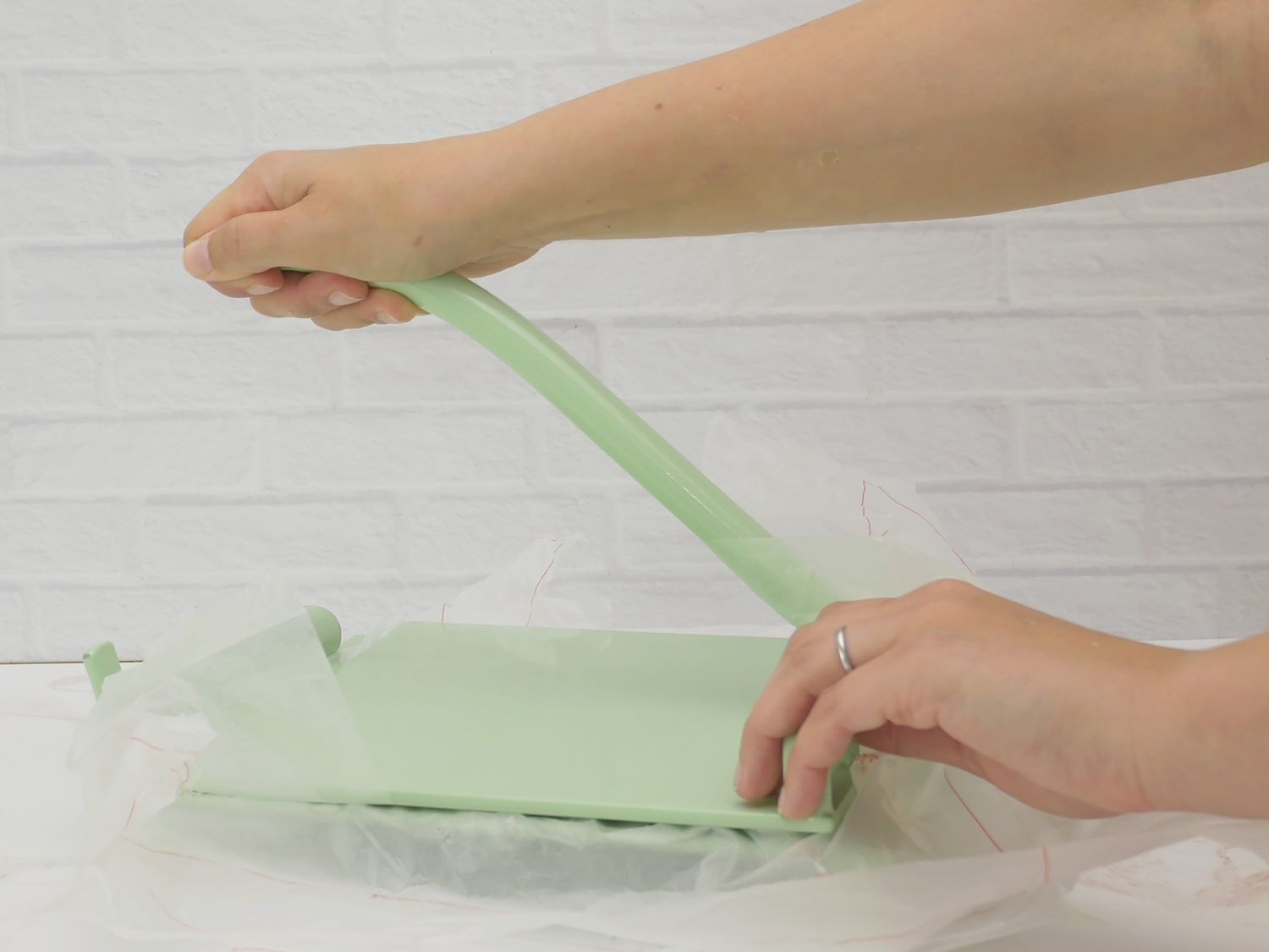 a person using pressing the handle down on a tortilla press