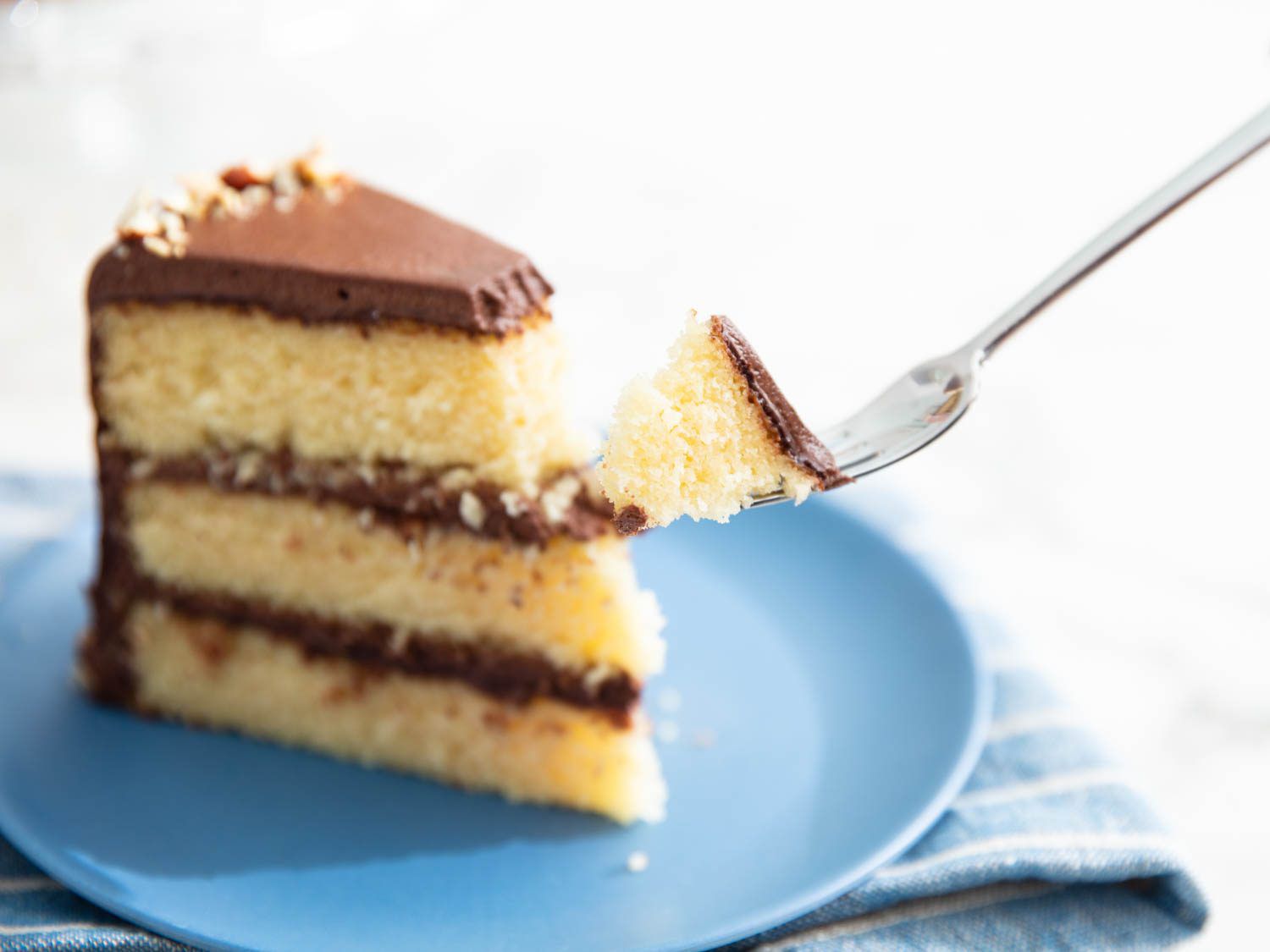 一块三层的黄色蛋糕，上面有巧克力糖霜
