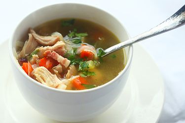 剩下的感恩节火鸡汤:用培根、胡萝卜、芹菜、洋葱和欧芹片做成的小白碗