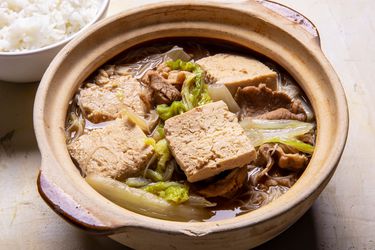 Serving bowl of Frozen Simmered Tofu Soup with Pork, Cabbage, and Rice Noodles with rice alongside