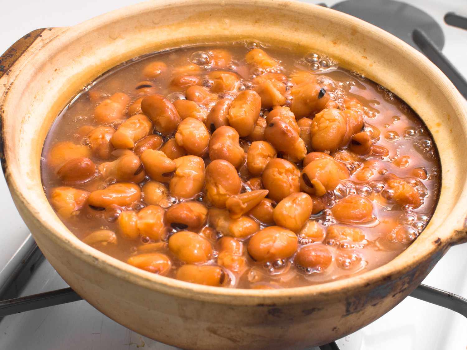 A ceramic cooking vessel of simmering ful medames.