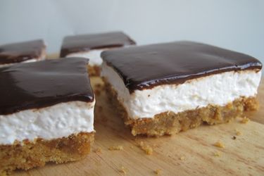 Four homemade Mallomar bars on a wood cutting board.