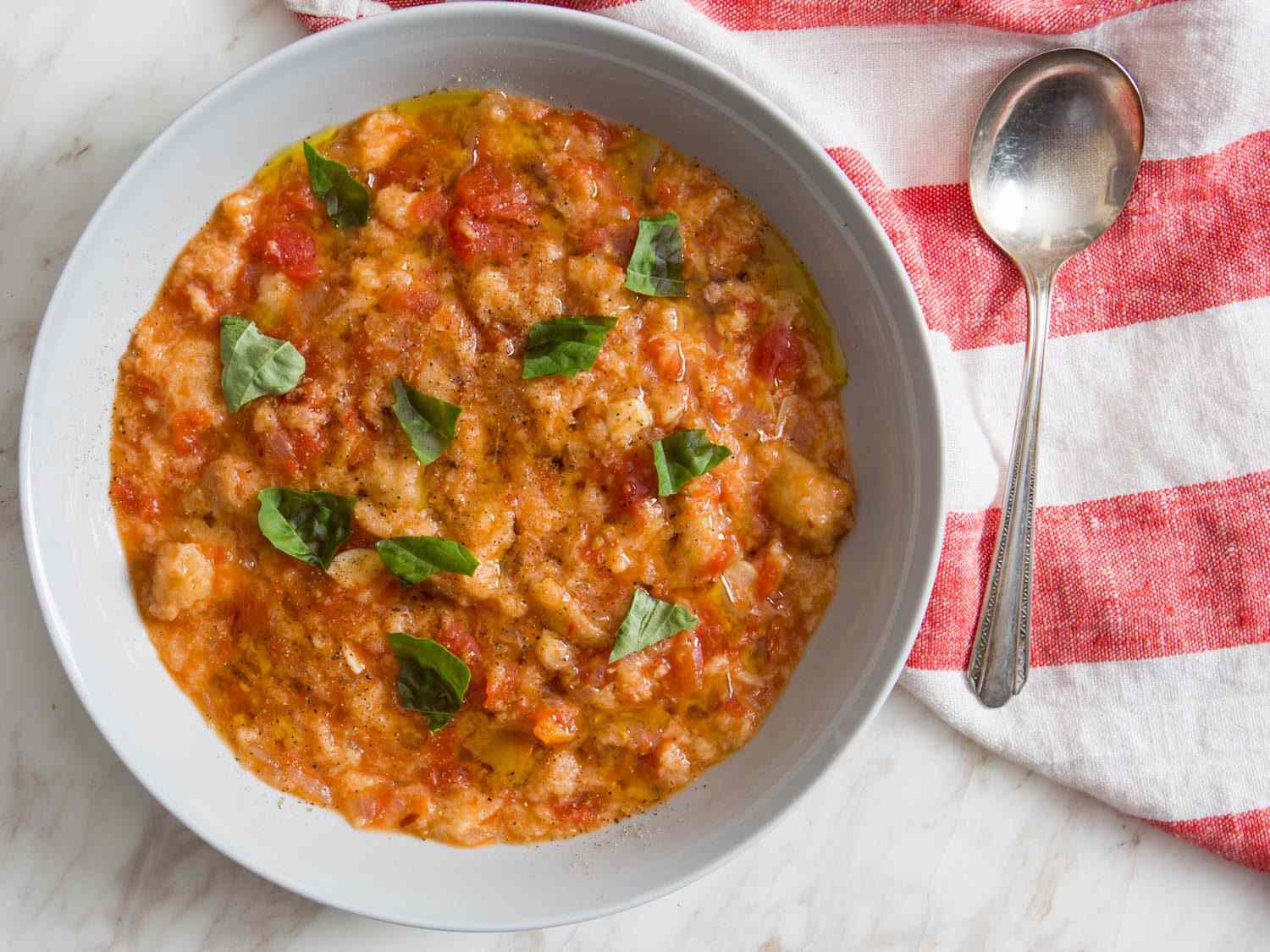 A bowl of pappa al pomodoro, scattered with torn basil leaves.