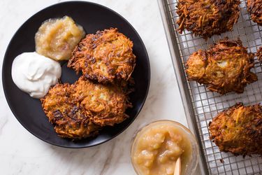 Latkes on a wire rack and three on a plate ready to serve