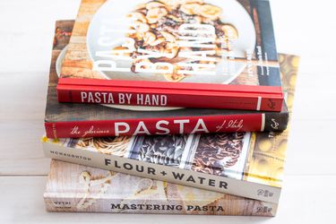一叠四本关于意大利面的烹饪书。